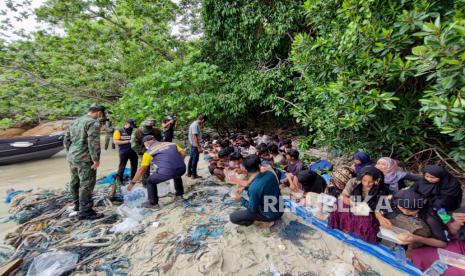 Belasan Pengungsi Rohingya Tenggelam dan Hilang di Teluk Benggala. Foto: Foto selebaran yang dirilis oleh Angkatan Laut Kerajaan Thailand menunjukkan seorang tentara Thailand membantu pengungsi Rohingya setelah ditemukan di pulau Dong, dekat perbatasan Thailand-Malaysia di provinsi paling selatan Satun di Thailand, 04 Juni 2022 (dikeluarkan 05 Juni 2022).