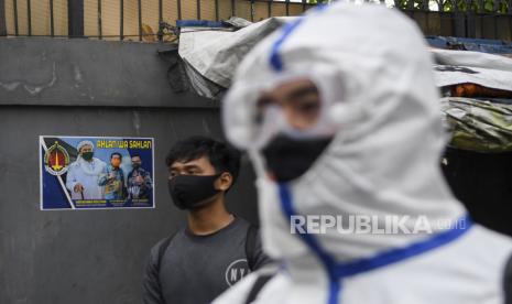 Anggota kepolisian dengan mengenakan hazmat bersiap menyemprotkan cairan disinfektan di kawasan Petamburan III, Jakarta Pusat, Minggu (22/11/2020). Penyemprotan tersebut dilakukan menyusul adanya temuan kasus terkonfirmasi positif Covid-19 di kawasan Petamburan. Kerumunan massa di Petamburan akibat acara pernikahan putri Habib Rizieq Shihab dan acara Maulid Nabi SAW dipandang kepolisian mengandung unsur pidana pelanggaran aturan karantina kesehatan.