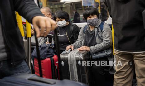  Wisatawan menaiki kereta pertama menuju stasiun Lok Ma Chau, titik penyeberangan perbatasan dengan Tiongkok, di Hong Kong, Tiongkok, Ahad (8/1/2023). 