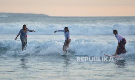 Sejumlah peselancar perempuan yang mengenakan busana kebaya beratraksi selancar di Pantai Kuta, Badung, Bali, Minggu (16/4/2023). Kegiatan tersebut diselenggarakan untuk menyambut peringatan Hari Kartini sekaligus mengenalkan busana kebaya khususnya kepada wisatawan mancanegara. 