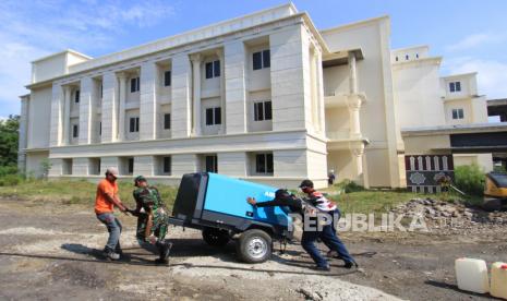 Petugas gabungan menyiapkan peralatan di gedung Asrama Haji Indramayu, Jawa Barat, Jumat (18/6/2021). Pemerintah Kabupaten Indramayu menyiapkan Asrama Haji sebagai ruang isolasi COVID-19 untuk pasien positif yang bergejala ringan dan tidak bergejala. 