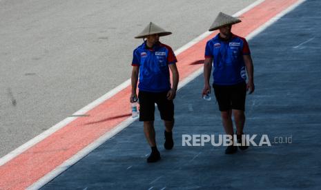 Petugas berjalan mengenakan topi caping usai melakukan pemeriksaan lintasan di Pertamina Mandalika International Street Circuit, Lombok Tengah, NTB, Kamis (17/3/2022). Gelaran balap motoGP 2022 bertajuk Pertamina Grand Prix of Indonesia akan berlangsung pada 18-20 Maret 2022. Republika/Thoudy Badai