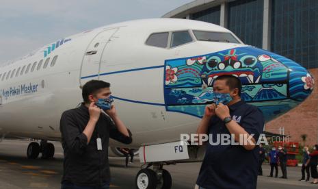 Direktur Utama Garuda Indonesia Irfan Setiaputra (kanan) berbincang dengan pemenang lomba desain livery masker pesawat Jailani (kiri) saat peluncuran pesawat Garuda Indonesia Boing 737-800 NG bercorak khusus yang menampilkan visual masker bertema Indonesia Pride pada bagian moncong pesawat,  di Hanggar GMF AeroAsia Bandara Soekarno Hatta, Tangerang, Banten, Senin (12/10/2020). Pemberian gambar masker pada pesawat merupakan dukungan Garuda Indonesia terhadap program edukasi pemerintah melalui kampanye Ayo Pakai Masker.