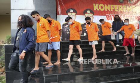 Petugas polisi berpakaian polos mengawal tersangka yang ditangkap dalam penggerebekan pesta seks sesama jenis atau gay, saat konferensi pers di Mabes Polri Jakarta di Jakarta.