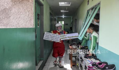 Anggota komunitas Badut Nyentrik Cimahi Bandung Sauyunan (Necis) melakukan kampanye kewaspadaan penyakit gagal ginjat akut di MI Darussalam, Jalan Caringin, Babakan Ciparay, Kota Bandung, Jumat (21/10/2022). Kegiatan tersebut digelar dalam rangka kampanye kesadaran dan kewaspadaan serta ungkapan peduli terhadap bahaya penyakit Gangguan Ginjal Akut Atipikal yang terjadi pada anak usia 0-18 tahun. Republika/Abdan Syakura