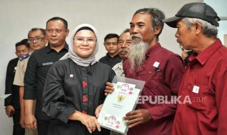 Bupati Indramayu Nina Agustina menyerahkan sertifikat tanah program PTSL kepada warga Desa Arjasari, Kecamatan Patrol, di aula RSUD MA Pantura Sentot Patrol, Kabupaten Indramayu, Selasa (9/1/2024). 