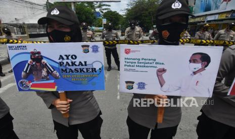 Sejumlah Polwan membawa poster imbauan untuk mematuhi protokol kesehatan COVID-19 saat melakukan pengamanan aksi unjuk rasa penolakan UU Cipta Kerja oleh aliansi mahasiswa Kota Palu di Palu, Sulawesi Tengah, Kamis (22/10/2020). Ajakan tersebut guna mengingatkan pengunjuk rasa untuk selalu mematuhi protokol kesehatan guna mencegah penyebaran COVID-19 yang rawan terjadi dalam aksi unjuk rasa karena melibatkan banyak orang. 