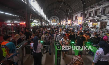 Penumpang kereta rel listrik (KRL) Commuterline Jabodetabek mengantre untuk keluar dari Stasiun Jakarta Kota. Pemprov DKI bersama kepolisian terus menjaga keamanan selama libur lebaran.