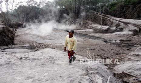 Tim SAR Cari Operator Alat Berat yang Hilang di Semeru. Warga berjalan di samping jalur lahar panas Gunung Semeru di kawasan Pronojiwo, Lumajang, Jawa Timur, Rabu (2/12/2020). Gunung Semeru mengalami erupsi yang menyebabkan awan panas letusan meluncur ke arah Curah Besuk Kobokan sepanjang 11 kilometer dengan durasi kemunculan awan panas selama tiga jam serta status level II atau waspada. 