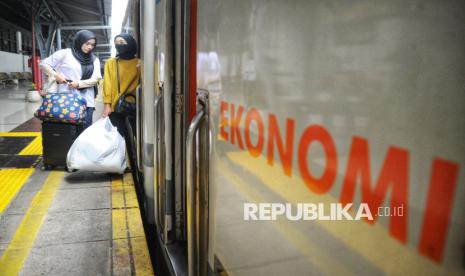 Sejumlah penumpang bersiap memasuki kereta api jarak jauh di Stasiun Pasar Senen, Jakarta Pusat, Ahad (26/1/2025).