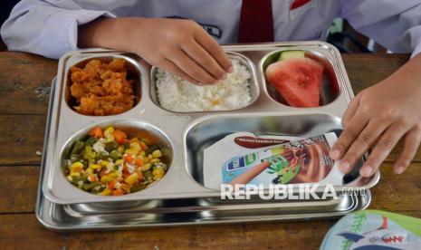 Para pelajar menikmati Makan Bergizi Gratis (MBG). Menurut Kementerian PPPA, program MBG sangat baik untuk memastikan pemenuhan gizi anak.