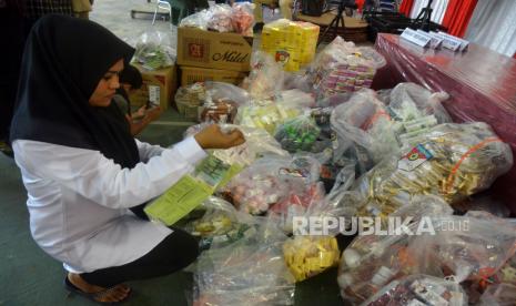 Petugas mendata barang bukti berupa kosmetik ilegal saat rilis kasus. BPOM sebut permintaan kosmetik yang tinggi memicu peredaran produk ilegal.