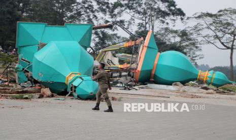 Petugas Satpol PP Kabupaten Bogor berjalan melewati bangunan yang telah dibongkar di tempat wisata Hibisc Fantasy Puncak, Kabupaten Bogor, Jawa Barat, Kamis (6/3/2025). Gubernur Jawa Barat Dedi Mulyadi memerintahkan wahana Hibisc Fantasy Puncak, Bogor tersebut untuk dibongkar karena taman rekreasi yang dikelola anak perusahaan BUMD PT Jaswita yakni PT Jaswita Lestari Jaya itu telah melanggar aturan alih fungsi lahan dengan mengelola kawasan yang seharusnya seluas 4.800 meter persegi menjadi 15.000 meter persegi. 