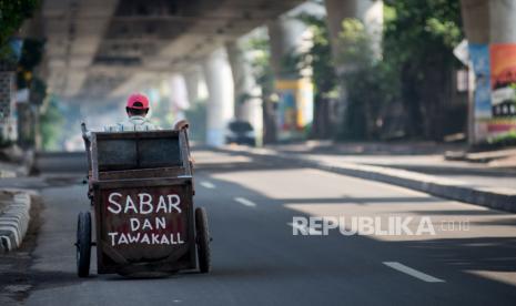 Warga mendorong gerobak saat pemberlakuan pembatasan sosial berskala besar (PSBB)  untuk menekan penyebaran COVID-19 di kawasan Blok M, Jakarta, Ahad (12/4). Memasuki hari ketiga pemberlakuan pembatasan sosial berskala besar (PSBB) sejumlah ruas jalan di Jakarta mulai sepi dari kendaraan roda dua dan empat