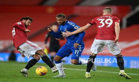 Joshua King (tengah) dari Everton beraksi melawan Bruno Fernandes (kiri) dari Manchester United dan Scott McTominay (kanan) selama pertandingan sepak bola Liga Utama Inggris antara Manchester United dan Everton FC di Manchester, Inggris, 6 Februari 2021.