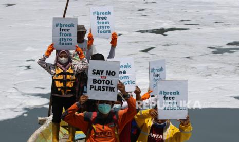 Sejumlah aktivis lingkungan dari Mupalas, Komunitas Tolak Plastik dan Ecoton membentangkan poster saat kampanye bebas dari plastik di Sungai Tambak Wedi, Surabaya, Jawa Timur, Kamis (18/3/2021). Selain melakukan kampanye tersebut mereka juga melakukan uji kualitas air sungai yang diketahui telah tercemar limbah. 