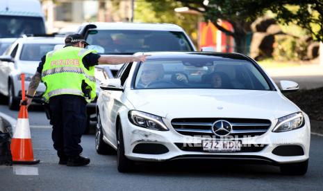 Seorang perwira polisi mengarahkan mobil untuk pemeriksaan lebih lanjut di sebuah pos pemeriksaan di perbatasan negara bagian Queensland-New South Wales di Coolangatta di Gold Coast, Queensland, Australia, 01 Juli 2020. Queensland akan membuka perbatasannya dengan semua negara bagian dan teritori lain, kecuali Victoria, pada 10 Juli.