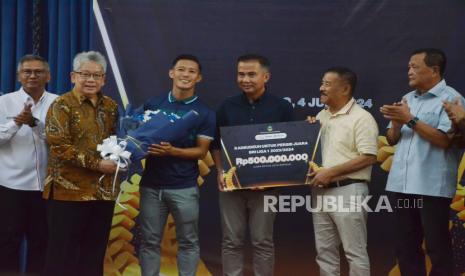 Dirut Bank BJB Yuddy Renaldi memberikan bunga kepada pemain Persib Henhen Herdiana bersama Pj Gubernur Jabar Bey Machmudin, dan Manajer Persib Bandung Umuh Muchtar saat penyerahan Kadeudeuh Persib Juara, di Gedung Sate, Kota Bandung, Selasa (4/6/2024). Uang kadeudeuh tersebut berasal dari tiga badan usaha milik daerah (BUMD) yakni Bank BJB, Migas Utama Jabar, dan Jamkrida Jabar atas prestasi Persib menjuarai Liga 1 2023-2024.