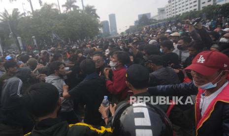 Massa saat memukul Pegiat Media Sosial Ade Armando saat terjadi kericuhan di depan Gedung DPR, Jakarta, Senin (11/4/2022). Aksi unjuk rasa yang berujung ricuh tersebut dibubarkan oleh aparat kepolisian dengan menembakan gas air mata dan water canon. Republika/Putra M. Akbar