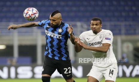 Arturo Vidal dari Inter Milan, kiri, menantang bola dengan Alassane Plea dari Moenchengladbach selama pertandingan sepak bola grup B Liga Champions antara Inter Milan dan Borussia Moenchangladbach di stadion San Siro di Milan, Italia, Rabu, 21 Oktober 2020.