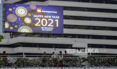 Sejumlah warga melintasi jembatan penyeberangan orang (JPO) di kawasan Sudirman, Jakarta, Selasa (29/12). Direktorat Lalu Lintas Polda Metro Jaya berencana menutup ruas Jalan Jenderal Sudirman hingga Jalan MH Thamrin bagi kendaraan dan manusia pada saat malam tahun baru 2021 untuk mengantisipasi penyebaran virus Corona (Covid-19). Republika/Putra M. Akbar