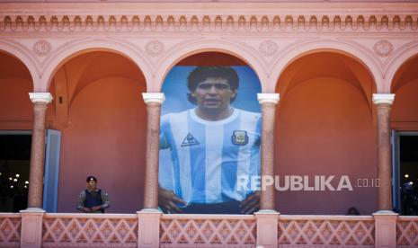  Poster raksasa Diego Maradona dipajang di balkon istana presiden yang dikenal sebagai Casa Rosada atau Pink House, di Buenos Aires, Argentina, Kamis, 26 November 2020. Pemain sepak bola hebat Argentina yang termasuk di antara pemain terbaik yang pernah dan yang memimpin negaranya meraih gelar Piala Dunia 1986 meninggal karena serangan jantung di rumahnya pada Rabu di usia 60 tahun.