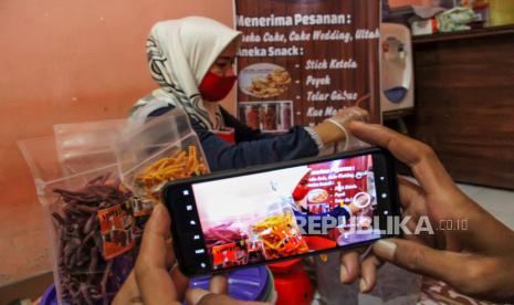 Pengusaha Usaha Mikro Kecil Menengah (UMKM) memotret produk makanan stik ketela untuk dipasarkan melalui media sosial, di Lhokseumawe, Aceh. UMKM produk makanan industri rumahan itu masih bertahan dengan inovasi produk dan berusaha menangkap peluang pemasaran secara daring di tengah pandemi Covid-19. 