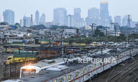 Dua rangkaian KRL melintas dengan latar belakang permukiman padat penduduk dan gedung bertingkat di kawasan Tanah Abang, Jakarta, Kamis (19/11). Penurunan suku bunga perbankan masih bisa terus dioptimalkan seiring dengan penahanan suku bunga acuan Bank Indonesia. 