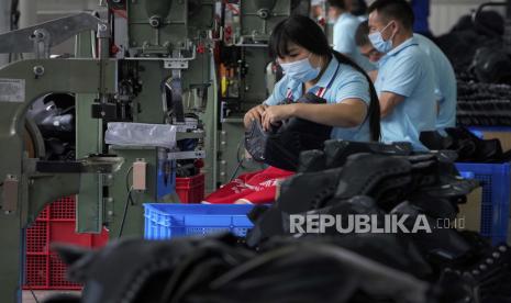  Pekerja mengenakan masker wajah untuk membantu mengekang penyebaran virus corona perakitan sepatu seluncur es di sebuah pabrik manufaktur di taman industri peralatan olahraga es dan salju di Zhangjiakou di provinsi Hebei, China barat laut, Kamis, 15 Juli 2021. 