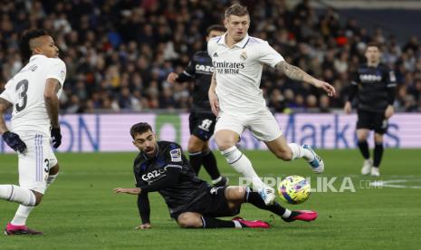 Gelandang Real Madrid Toni Kroos (kanan) berduel memperebutkan bola dengan gelandang Real Sociedad Brais Mendez (tengah) saat pertandingan sepak bola LaLiga Spanyol antara Real Madrid dan Real Sociedad, di Madrid, Spanyol, 29 Januari 2023.