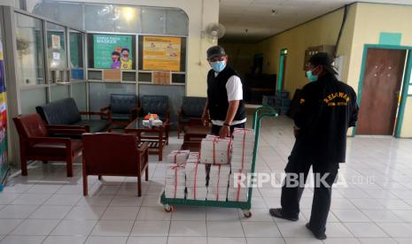 Petugas membawa makanan untuk pasien Covid-19 yang menjalani masa karantina di Shelter Tangguh Patmasuri, Bantul, Yogyakarta, Ahad (13/2/2022). Saat ini, ada 43 pasien Covid-19 menjalani karantina di Shelter Tangguh Patmasuri. Total kasus positif Covid-19 di Yogyakarta saat ini mencapai 4.468 orang. Beberapa tempat isolasi dibuka kembali dengan naiknya kasus Covid-19 sepekan terakhir.