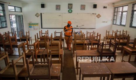 Petugas PPSU Kelurahan Palmerah menyemprotkan cairan disinfektan di lingkungan Madrasah Aliyah Negeri 22 Jakarta, Palmerah, Jakarta, Jumat (4/12). Penyemprotan tersebut dilakukan akibat sebanyak 21 guru dan 9 staf Tata Usaha (TU) di MAN 22 Jakarta terkonfirmasi positif Covid-19 usai melakukan perjalanan ke Yogyakarta. Republika/Thoudy Badai