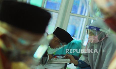 Sejumlah santri mengunakan masker dan pelindung wajah saat mengikuti kegiatan belajar membaca Al Quran,  di Diniyah Takmiliyah Awaliyah (DTA) Ummi Kulsum, Karawang, Jawa Barat, Selasa (25/8/2020). Kegiatan tersebut kembali dilaksanakan setelah terhenti selama tiga bulan akibat pandemi COVID-19 dengan menyesuaikan kondisi adaptasi kebiasaan baru melalui penerapan protokol kesehatan dan pengaturan shift belajar.