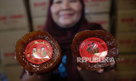 Seorang pekerja menyiapkan kue untuk perayaan imlek (ilustrasi).  Tahun baru imlek sangat identik dengan makanan yang berbahan dasar tepung dan bercita rasa manis. Sebut saja moon cake, manisan segi delapan, kue mangkuk, lapis legit, hingga dodol, makanan yang biasa tersaji pada perayaan terpenting warga Tionghoa tersebut.