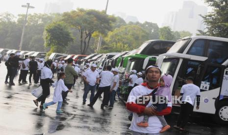 Sejumlah pemudik berjalan di dekat bus saat pelepasan program Mudik Bersama BUMN 2023 di Gelora Bung Karno, Jakarta, Selasa (18/4/2023). Sebanyak 78.017 pemudik mengikuti program Mudik Bersama BUMN 2023 yang bertajuk Mudik Dinanti Mudik di Hati yang merupakan salah satu implementasi bakti BUMN sebagai bentuk Tanggung Jawab Sosial dan Lingkungan.