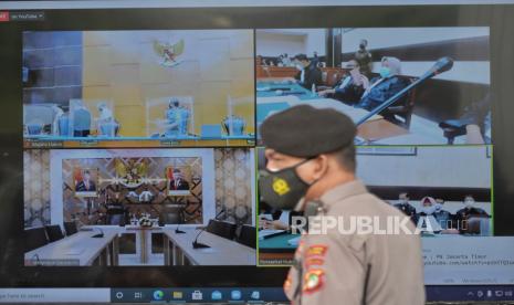 Layar yang menampilkan suasana sidang perdana atas kasus pelanggaran protokol kesehatan dengan terdakwa mantan pemimpin FPI Habib Rizieq Shihab (HRS) yang digelar secara virtual di Pengadilan Negeri Jakarta Timur, Selasa (16/3).