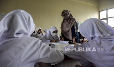 Guru memberikan pelajaran tambahan saat hari pertama masuk sekolah di SDN 025 Cikutra, Jalan Cikutra, Kota Bandung, Kamis (12/5/2022). Sekolah berbagai jenjang di Kota Bandung mulai kembali menggelar Pembelajaran Tatap Muka (PTM) setelah libur Lebaran 2022. Foto: Republika/Abdan Syakura