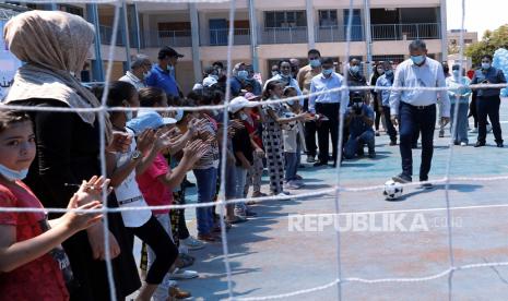 Philippe Lazzarini, Komisaris Jenderal Badan Bantuan dan Pekerjaan PBB untuk Pengungsi Palestina di Timur Dekat (UNRWA), bermain sepak bola di depan siswa yang berpartisipasi dalam perkemahan musim panas UNRWA di Sekolah Persiapan Pantai untuk anak perempuan, di pengungsian Shati kamp, ??Minggu, 4 Juli 2021. Menurut UNRWA telah memulai kamp musim panas untuk 150.000 anak di Jalur Gaza.