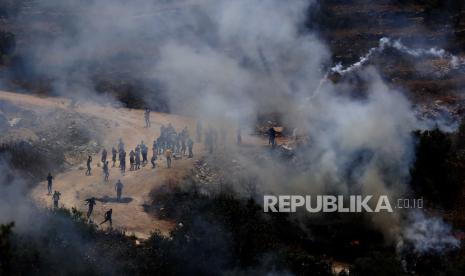 Liga Arab Sambut Baik Komisi PBB Selidiki Kejahatan Israel. Pengunjuk rasa Palestina berlindung dari gas air mata selama bentrokan dengan pasukan Israel setelah protes terhadap pemukiman Israel di Desa Beta dekat Kota Nablus, Tepi Barat, 28 Mei 2021.