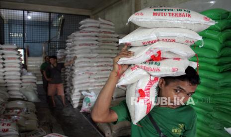 Pekerja memikul karung berisi beras di Pasar Simpang Limun, Kota Medan, Sumatera Utara, Jumat (24/2/2023). Menurut pedagang di pasar tersebut harga beras sejak dua pekan terakhir mengalami kenaikan dari harga Rp9.500 menjadi Rp11.500 per kilogram untuk beras medium, sedangkan untuk beras premium dari harga Rp54.000 menjadi Rp56.000 per kilogram.  