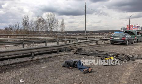  Mayat seorang pria tewas tergeletak di jembatan yang hancur di sebelah mobil-mobil terbengkalai yang ditinggalkan oleh orang-orang yang melarikan diri dari kota garis depan Irpin, wilayah Kyiv (Kiev), Ukraina, 07 Maret 2022. Irpin, kota yang terletak di dekat kota Kyiv itu memiliki beban berat pertempuran selama hampir seminggu antara militer Ukraina dan Rusia memaksa ribuan orang untuk melarikan diri dari kota.