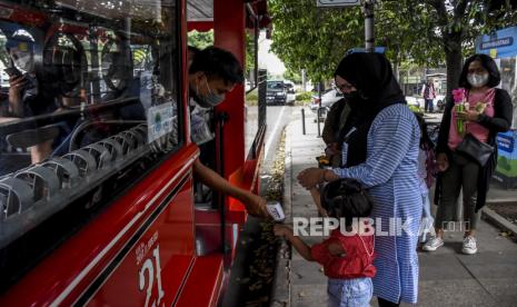 Petugas memeriksa suhu tubuh penumpang sebelum menaiki bus Bandung Tour On Bus (BANDROS) di Halte Bus Bandros di Jalan Diponegoro, Ahad (5/9). Bus wisata Bandung Tour On Bus (BANDROS) kembali beroperasi secara terbatas dengan menerapkan protokol kesehatan pencegahan Covid-19, seiring dengan menurunnya status Pemberlakuan Pembatasan Kegiatan Masyarakat (PPKM) di Kota Bandung menjadi Level 3. Foto: Republika/Abdan Syakura