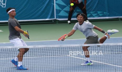 Petenis Jawa Timur Christoper Rungkat (kanan) dan David Agung (kiri) mengembalikan bola ke arah lawannya petenis Jawa Barat KareemAbdul Hakim/Rafly Febi Puti dalam pertandingan semifinal tenis ganda putra PON Papua 2021 di Jayapura, Papua, Rabu (6/10). Christo/David menang dengan skor 6-3 dan 6-0. 