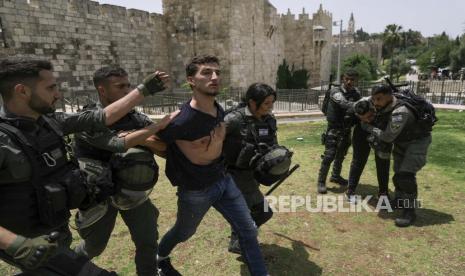 Anggota pasukan keamanan Israel menahan seorang pengunjuk rasa Palestina di dekat Gerbang Damaskus di luar Kota Tua Yerusalem saat warga Israel memperingati Hari Yerusalem, hari libur Israel yang merayakan penaklukan Kota Tua selama perang Timur Tengah 1967. Ahad, 29 Mei 2022. Pasukan Israel Terus Tahan Jenazah Remaja Palestina Tewas di Ramallah