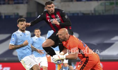 Bek AC Milan Theo Hernandez berebut bola dengan Kiper SS Lazio Pepe Reina pada pertandingan Serie A Italia di Olimpico Stadium, Roma, Italia, Senin (26/4). SS Lazio memenangkan pertandingan melawan AC Milan dengan skor akhir 3-0, melalui gol yang dicetak oleh Joaquin Correa dan CIro Immobile. EPA-EFE/MAURIZIO BRAMBATTI