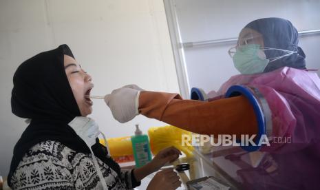 Tenaga medis mengambil sampel lendir pasien dari bilik swab test chamber saat tes swab massal (ilustrasi)