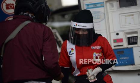 Petugas SPBU menggunakan alat pelindung wajah (Face Shield) saat melayani konsumen di SPBU 31-164-01 Margonda, Depok, Jawa Barat, Ahad (10/5). Petugas SPBU yang berhubungan langsung dengan komsumen tersebut menggunakan alat pelindung wajah sebagai upaya untuk melindungi diri, keluarganya maupun orang lain dalam upaya pencegahan penyebaran COVID-19