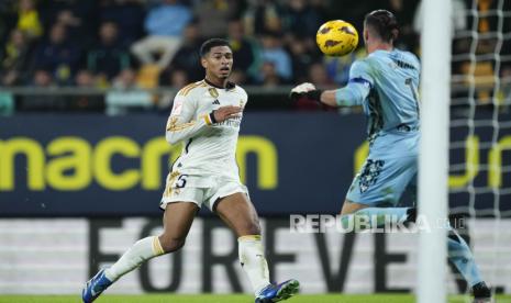 Gelandang serang Real Madrid, Jude Bellingham (kiri), mencetak gol ke gawang Cadiz dalam lanjutan La Liga Spanyol, Ahad (26/11/2023). 