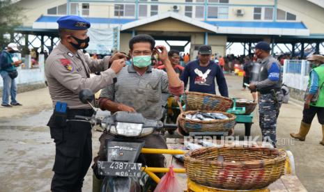 Anggota Polairud bersama prajurit TNI AL membagikan masker kepada nelayan dan pedagang keliling di pusat pelelangkan ikan Pelabuhan Perikanan Samudera, Kotaraja, Banda Aceh, Aceh, Selasa (24/11/2020). Pemerintah terus meningkatan penegakkan disiplin protokol kesehatan kepada masyarakat, salah satunya di pusat keramaian seperti tempat pelelangan ikan untuk menekan peningkatan kasus COVID-19. 