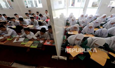 Pelajar muslim Indonesia belajar dengan pemisah di ruang kelas di Pondok Pesantren Sirajussa